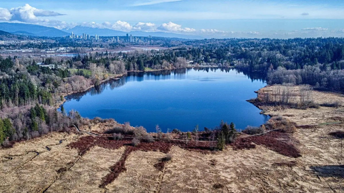 Deer Lake in Burnaby seen from above, with Metrotown and the mountains behind