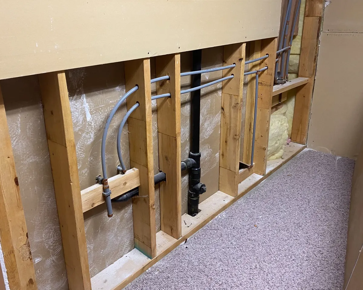 Grey Poly-B water lines exposed in an opened wall during a Prosafe repipe in North Vancouver