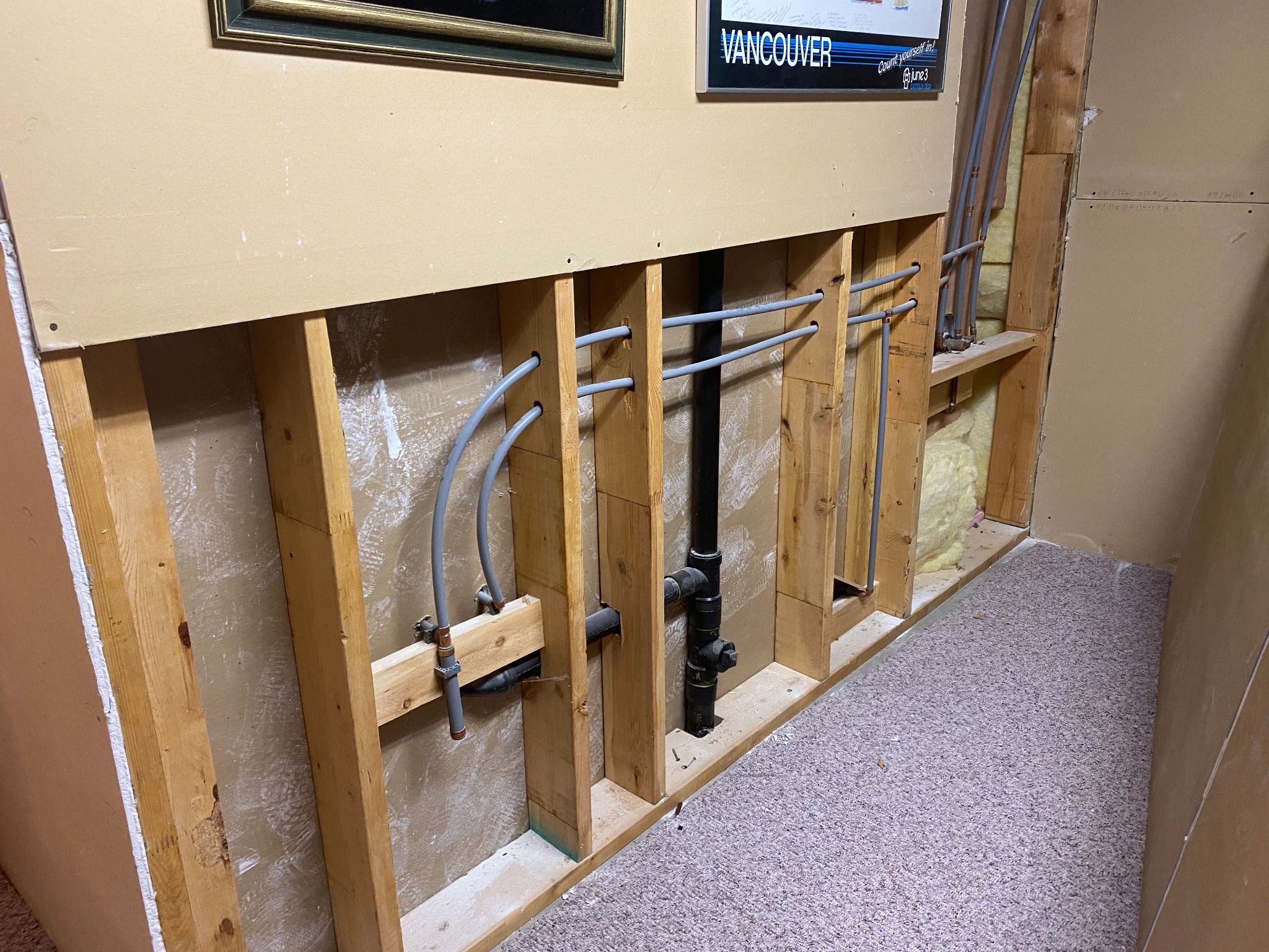 Grey Poly-B water lines behind an opened wall in an Upper Lonsdale, North Vancouver home