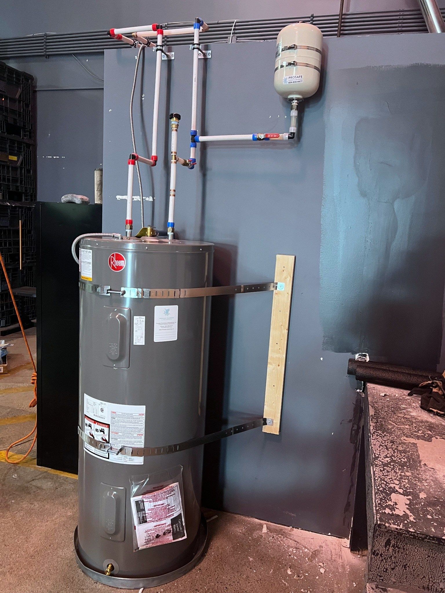 Electric hot water tank installation by Prosafe, strapped to the wall, with a thermal expansion tank