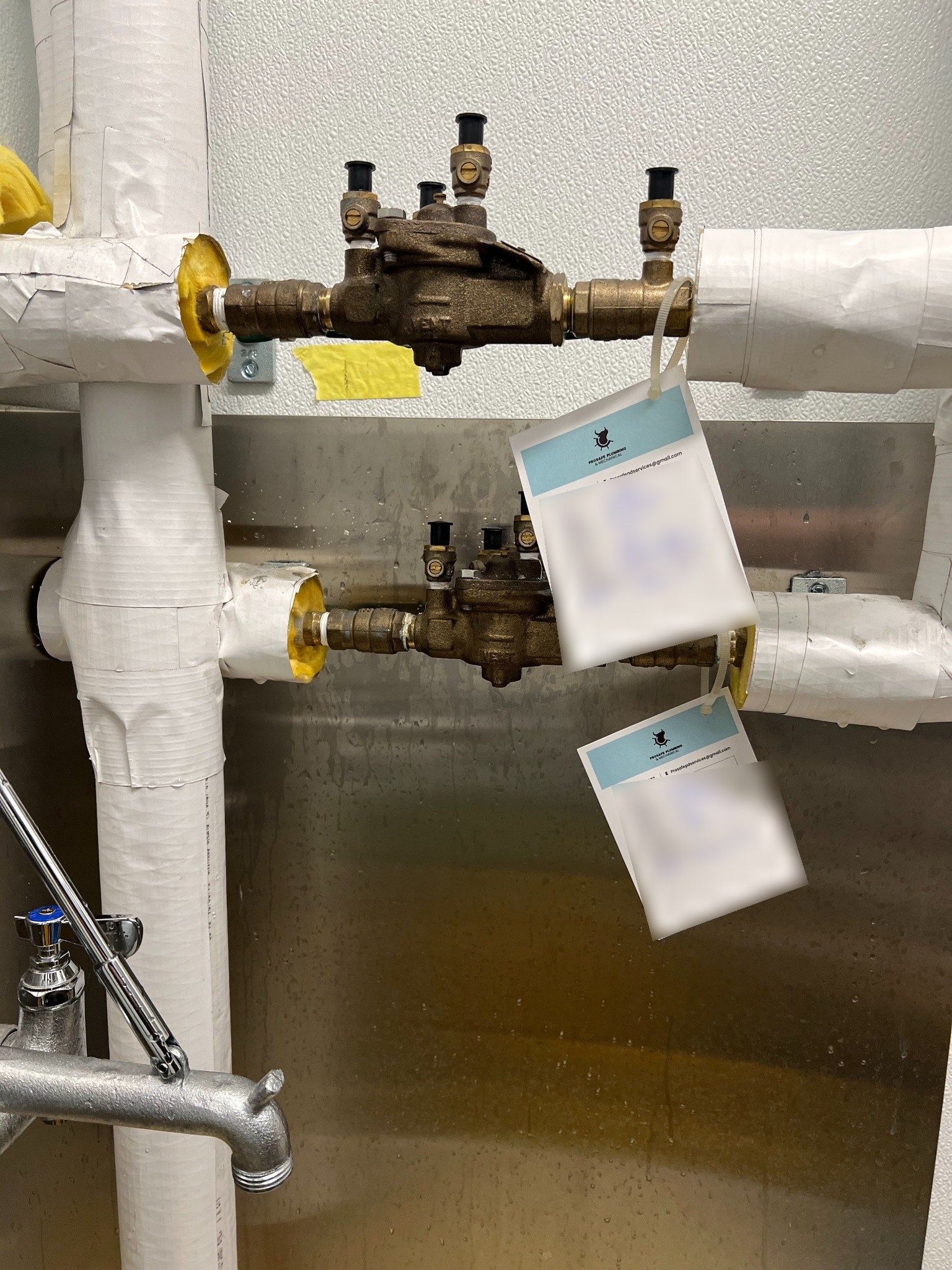 Two ½-inch reduced-pressure backflow assemblies with Prosafe test tags in a utility room